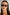 Front-facing view of rectangular sunglasses with a glossy black frame and green-tinted lenses. The slim silhouette features softly rounded corners for a modern take on a retro classic.