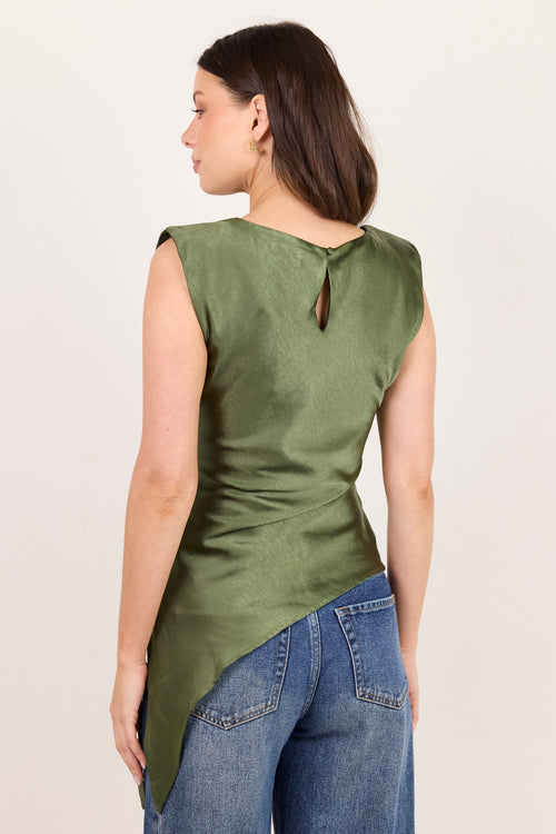 A woman shown from the back wearing a sleeveless olive green top with a small keyhole cutout at the neckline, paired with blue jeans, against a plain light beige studio background.