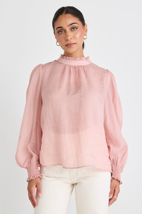 model wears a pink blouse