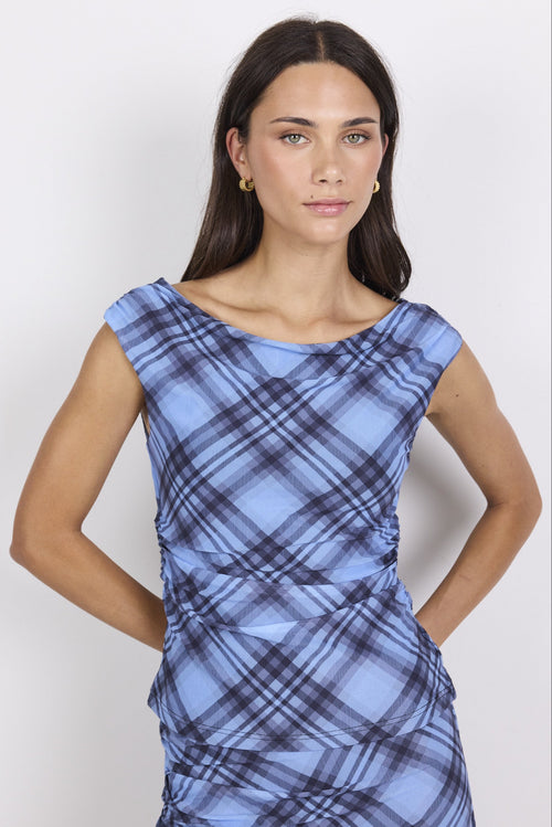 Woman wearing a blue plaid top against a white background