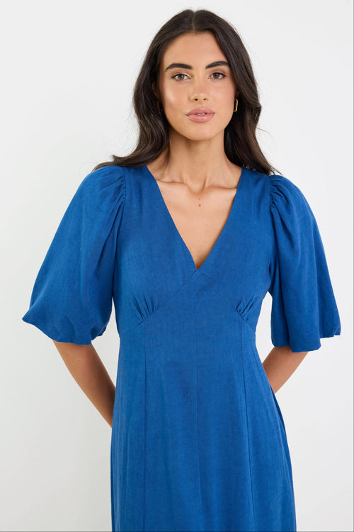 Woman wearing a blue dress against a white background