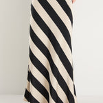 model wears a black and white stripe maxi skirt with a black tank top 