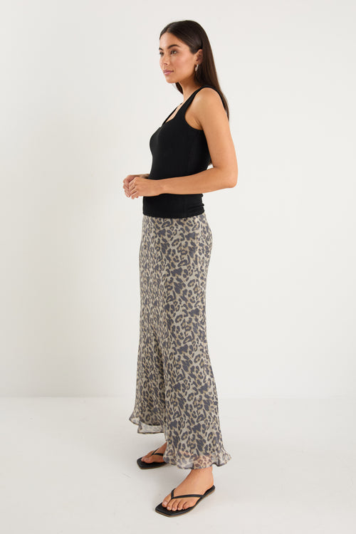 model wears a leopard maxi skirt with a black tank top