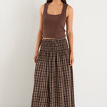 model wears a brown and beige check maxi skirt with a brown tank top