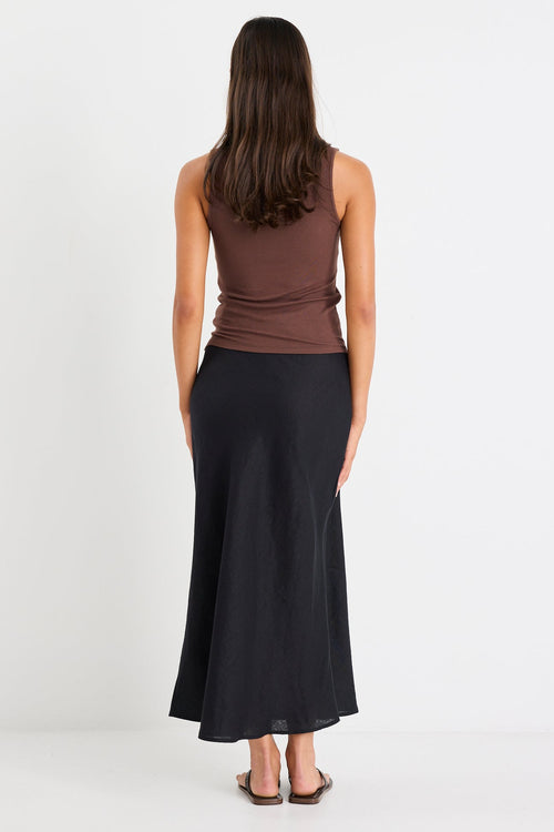 Woman wearing a black linen midi skirt and brown tank