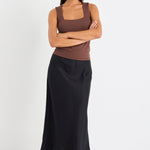 Woman wearing a black linen midi skirt and brown tank