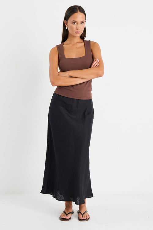 Woman wearing a black linen midi skirt and brown tank