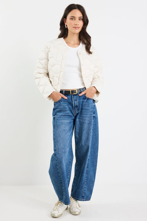 Woman wearing a white jacket and blue jeans on a white background
