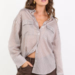 Woman wearing a striped shirt and brown pants on a white background