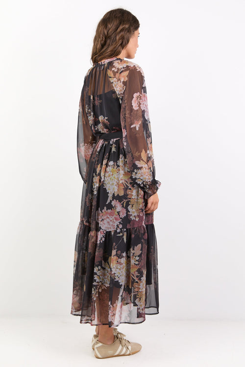 Woman wearing a floral dress with long sleeves on a white background