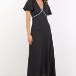 Woman wearing a black dress with ruffled sleeves on a white background