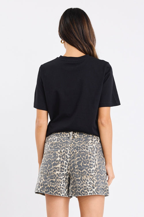 Woman wearing high-rise leopard print shorts with front patch pockets, styled with a black top.