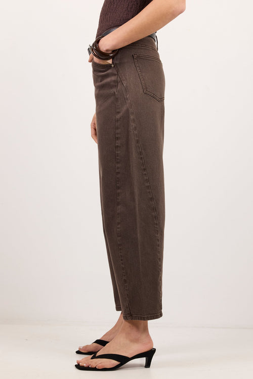 A model shown from the waist down wearing dark brown cropped jeans and black heeled thong sandals, standing against a plain white studio background.
col_pattern