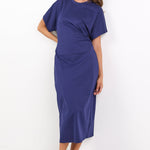 Woman wearing a blue dress standing against a white background