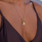 Tan model wearing a gold necklace