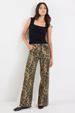 Woman wearing a black top and leopard print pants on a white background
