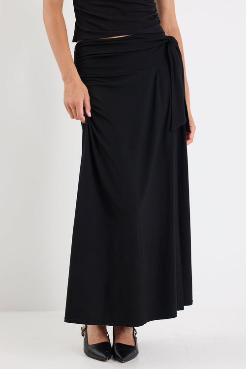 Person wearing a black dress with a white background