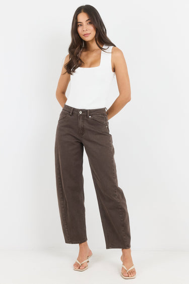 Woman wearing a white tank top and brown pants on a white background