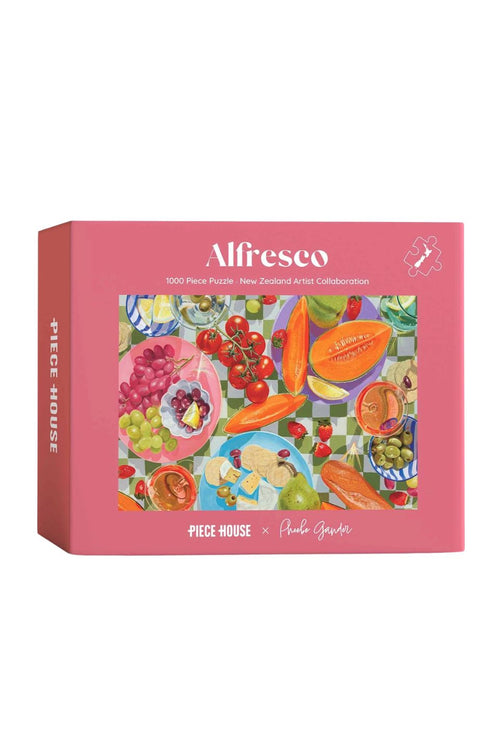 Alfresco x Paula Gouretti 'Piece House' 1000-piece jigsaw puzzle box. The packaging features a vibrant pink border with a colorful illustration of fresh fruits, grapes, and a checkered pattern in the center.