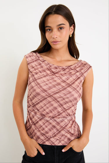 Model wearing a sleeveless blush check mesh top with a scoop neckline and ruched bodice