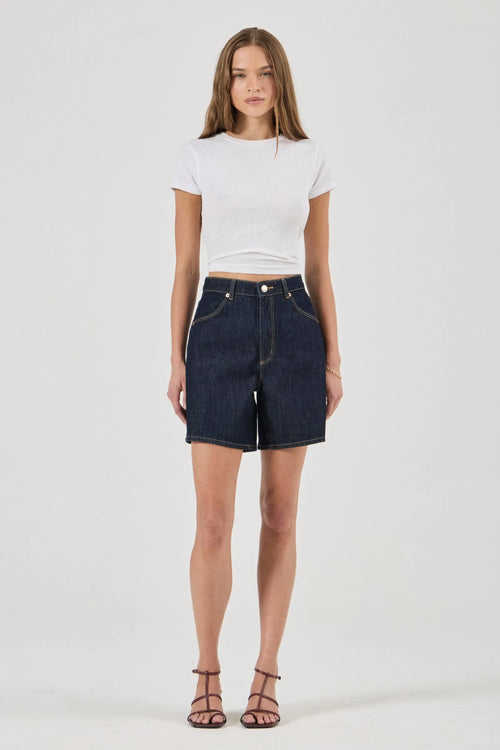Woman wearing a white t-shirt and dark denim shorts on a white background