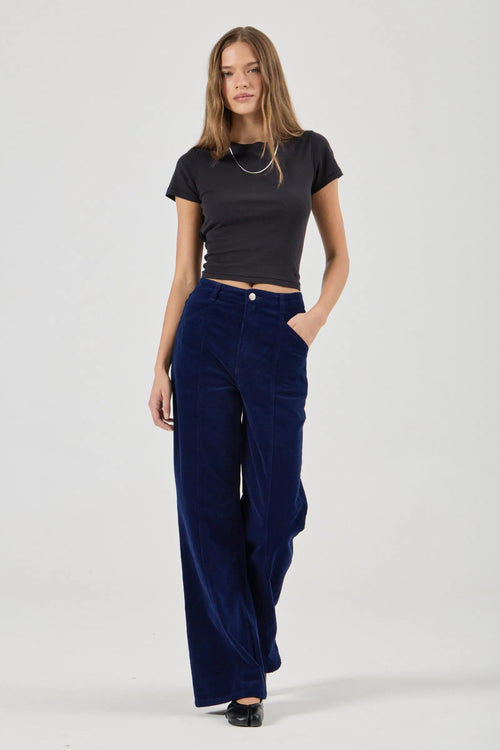 Woman wearing a black t-shirt and blue pants on a white background