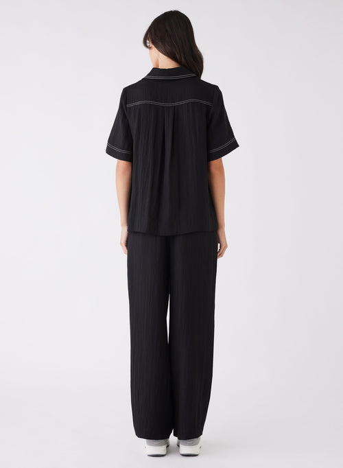 model wearing a black top with contrast stitching