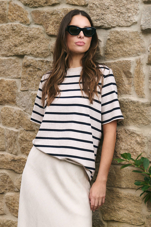 Model wearing a stripe tee and long beige skirt 
