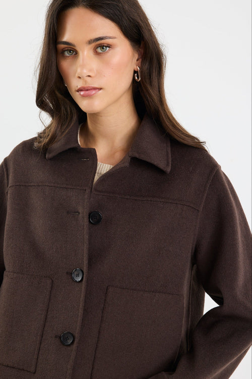 Woman wearing a brown jacket on a white background