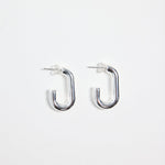 silver-plated brass huggie earrings with a rectangular shape, photographed flat on a white background.