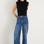 Model wears a black rib knit top with dark blue jeans