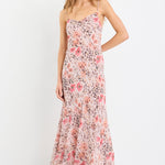 Woman wearing a strappy maxi dress in soft georgette with a floral and animal print blend, bias cut design, and flowing silhouette.