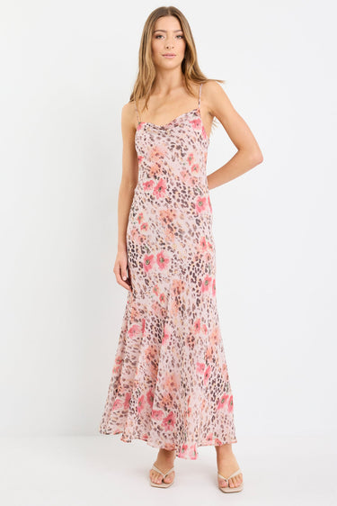 Woman wearing a strappy maxi dress in soft georgette with a floral and animal print blend, bias cut design, and flowing silhouette.