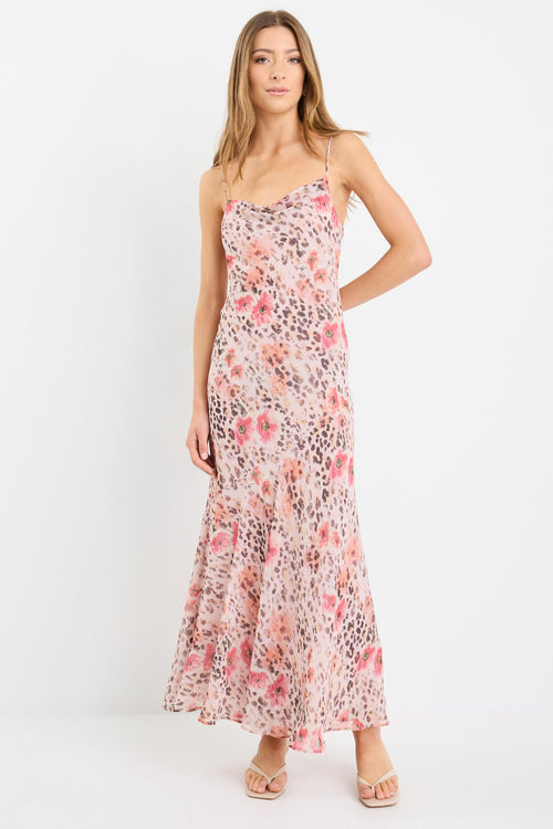 Woman wearing a strappy maxi dress in soft georgette with a floral and animal print blend, bias cut design, and flowing silhouette.