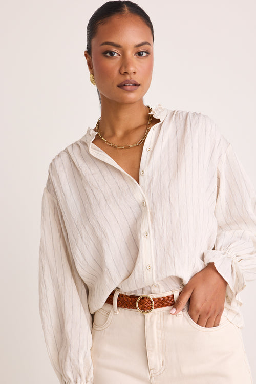 model wears a white stripe blouse