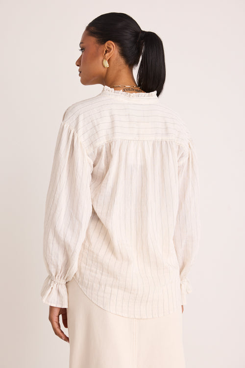 model wears a white stripe blouse