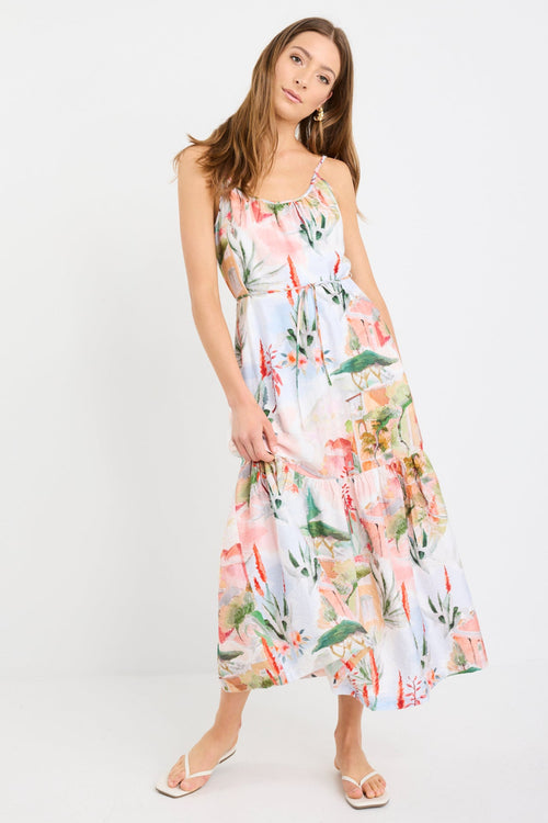 Woman wearing a Tuscan sunset-inspired strappy tiered midi dress with a vibrant print and flowing silhouette.
