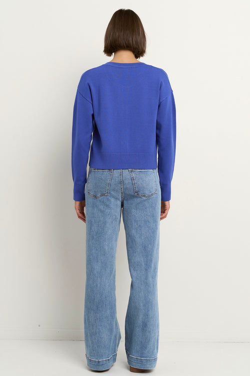 model wears a blue cardigan with light blue jeans