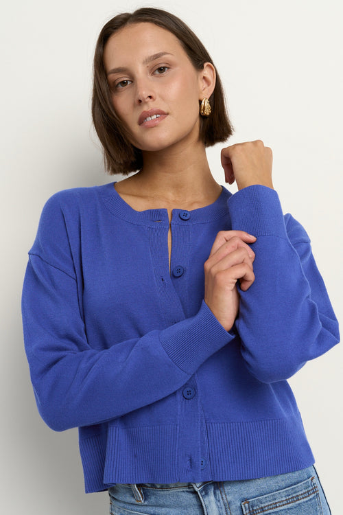 model wears a blue cardigan with light blue jeans