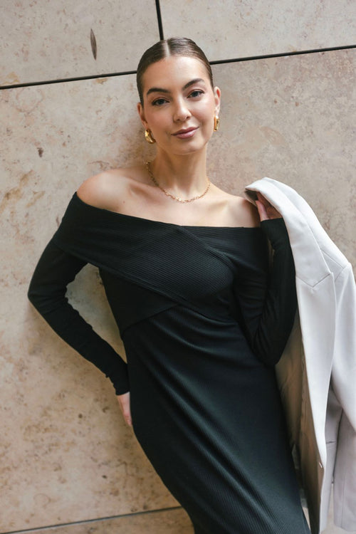 model wears a black off the shoulder maxi dress