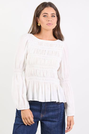 Woman wearing a white blouse and blue jeans on a white background