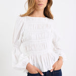 Woman wearing a white blouse with a plain background