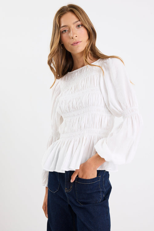 Woman wearing a white blouse with long sleeves on a white background