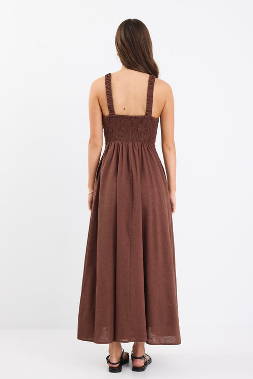 A chocolate brown dress with strappy sleeves and a shirred back for a flattering fit. Made from a breathable blend of 45% Linen and 55% Cotton, and fully lined for comfort.