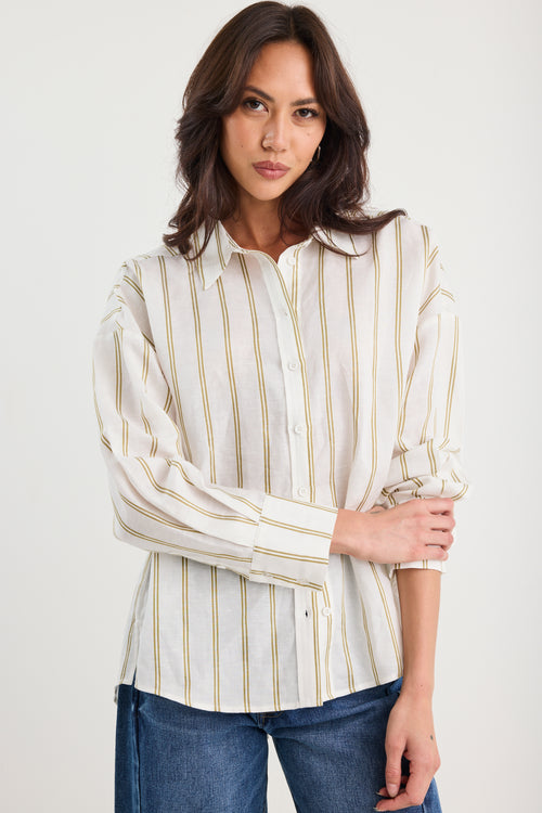 Woman wearing a striped shirt and jeans against a white background