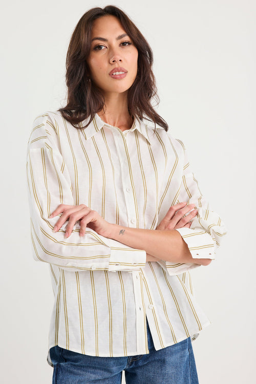 Woman wearing a striped shirt and jeans against a white background