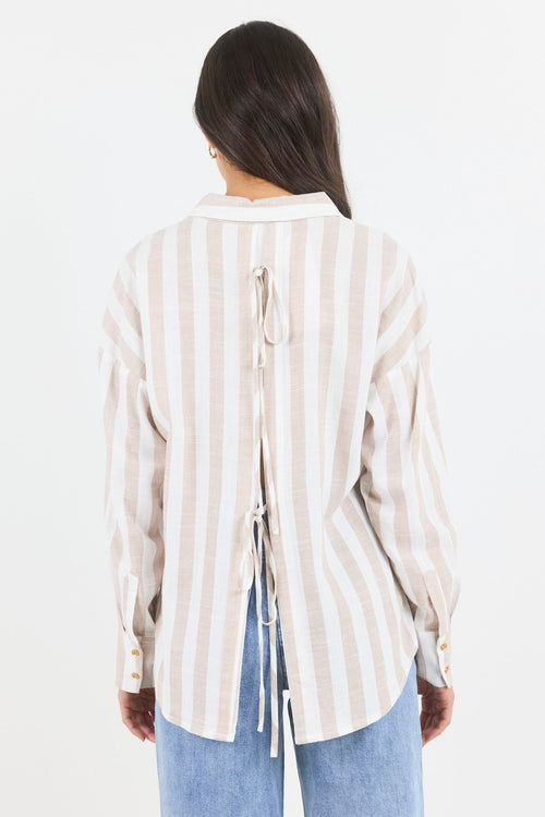 Person wearing a striped shirt and blue jeans on a white background