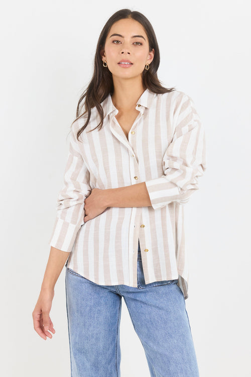 Woman wearing a striped shirt and jeans on a white background