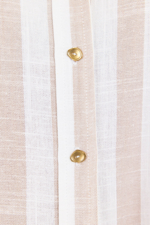 Close-up of a striped fabric with gold buttons on a white background