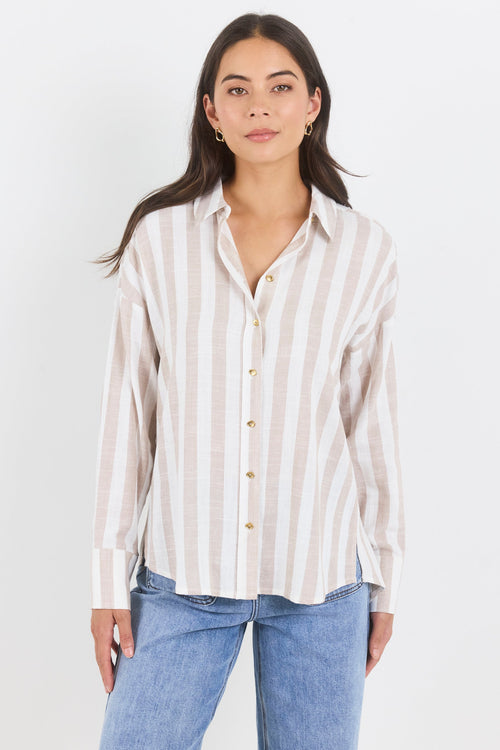 Woman wearing a striped shirt and blue jeans on a white background